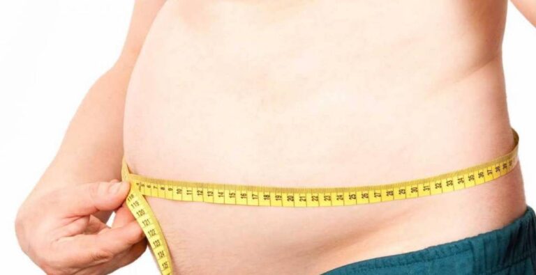 Paciente midiendo el perímetro abdominal como indicador de obesidad y grasa visceral.
