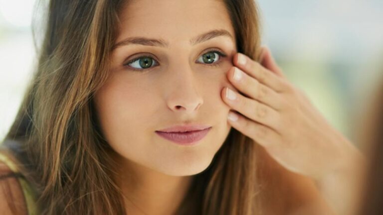 Mujer joven con piel saludable aplicando cuidados faciales en casa, ideal para ilustrar consejos de dermatología estética de Airklinic Valencia.